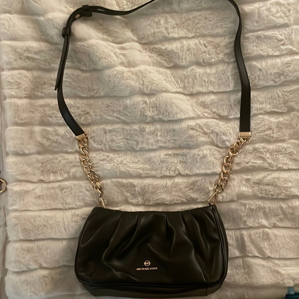 Small Michael Kors black purse with long gold chain and leather strap.